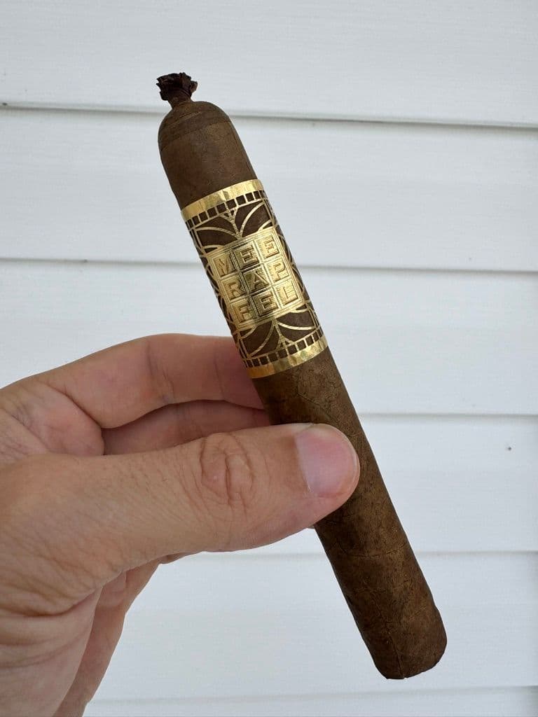 Unlit Meerapfel Richard with pig tail cap and ornate gold band against white siding