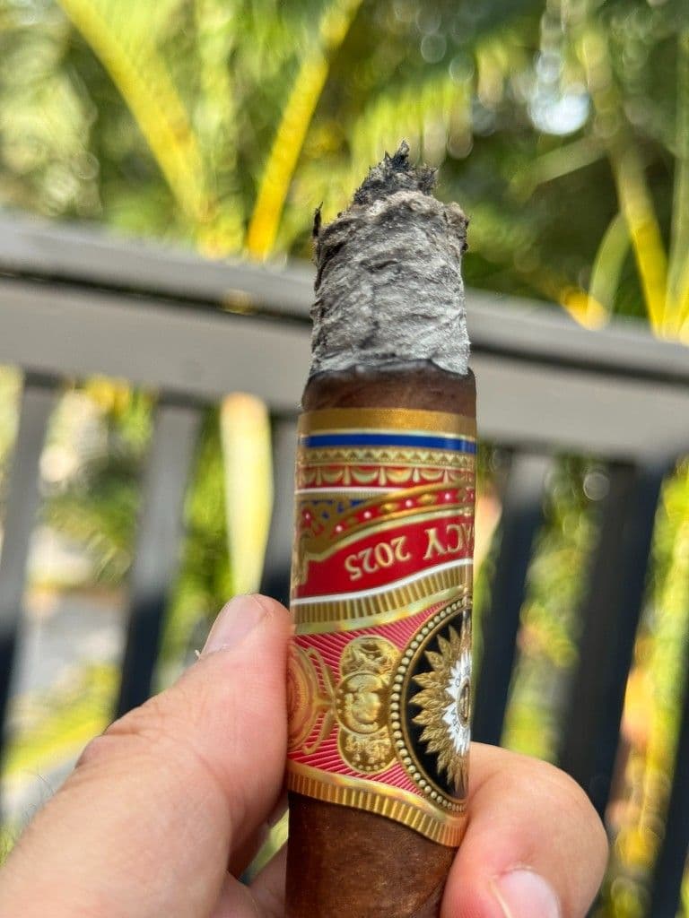 Perdomo Legacy 2025 band with stacked coin ash mid-smoke