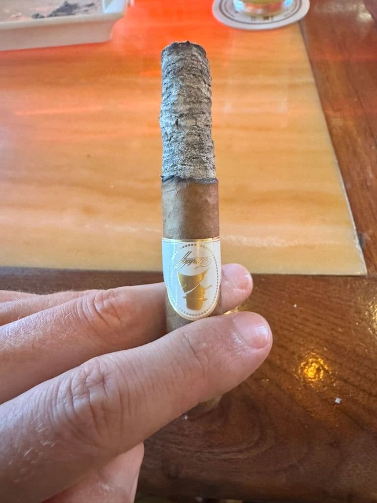 Davidoff Winston Churchill Petit Corona with long firm ash on a wooden table
